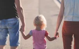 Free parent holding child's hand